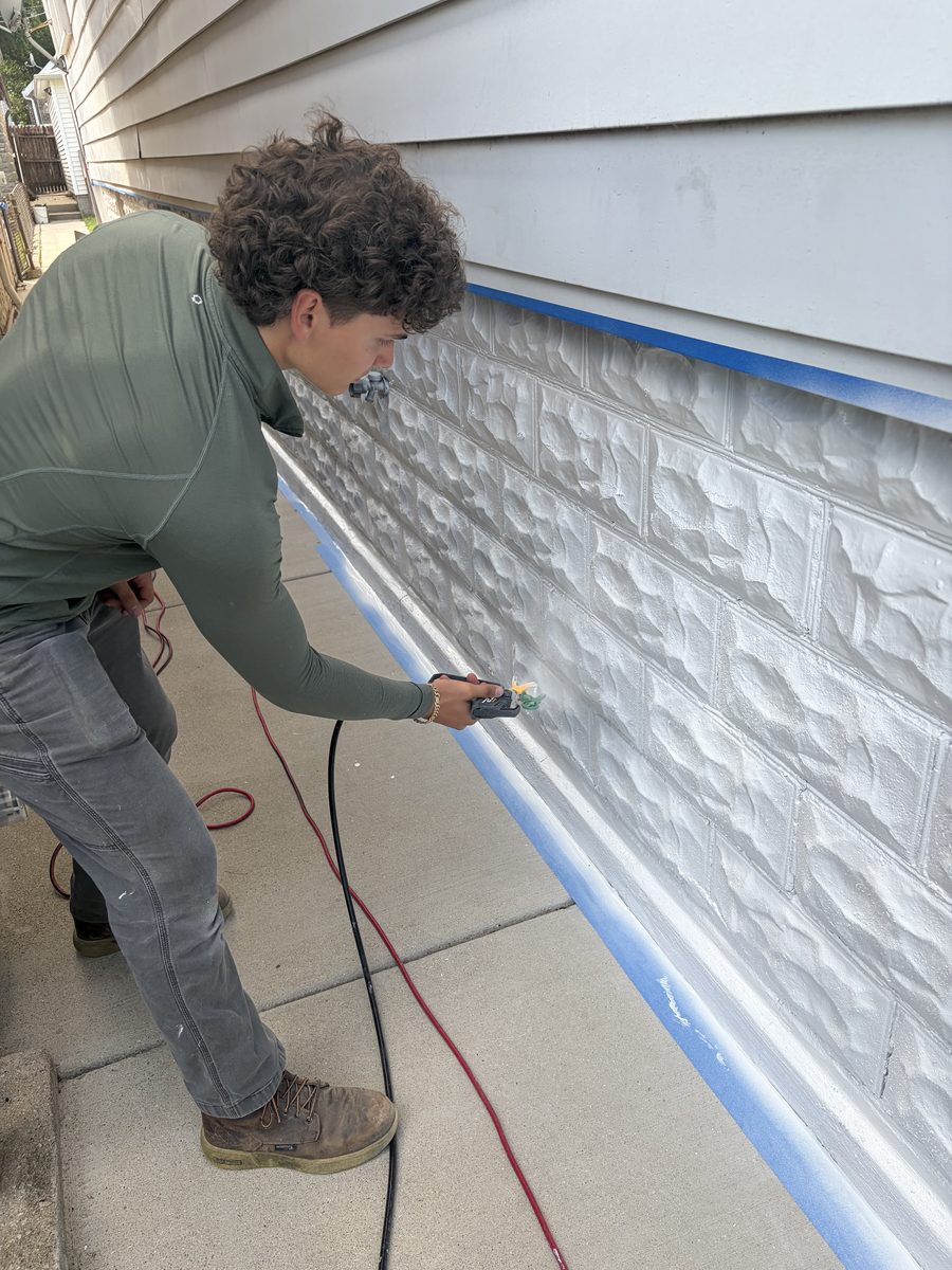 Spraying a fresh coat on a house exterior