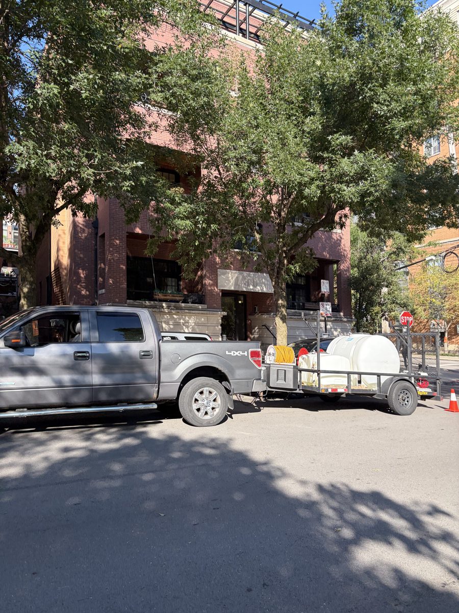 Moe Maintenance truck and trailer on a Chicago residential street